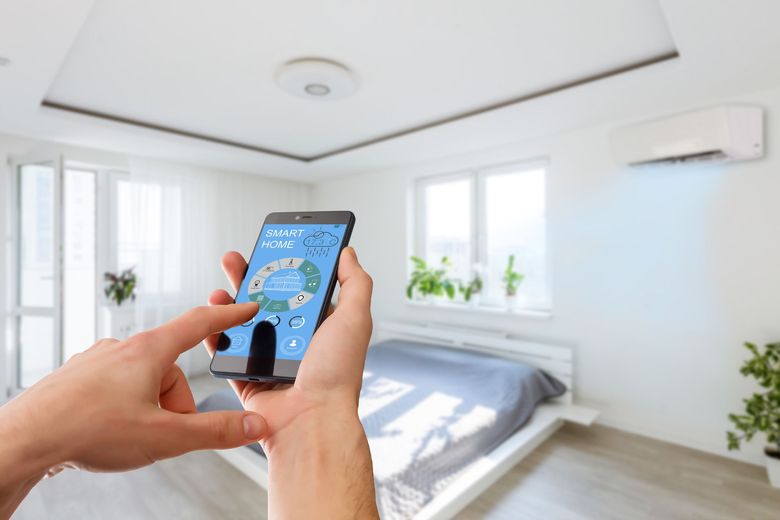 Hands holding a smartphone controlling a bright white bedroom’s smart home app