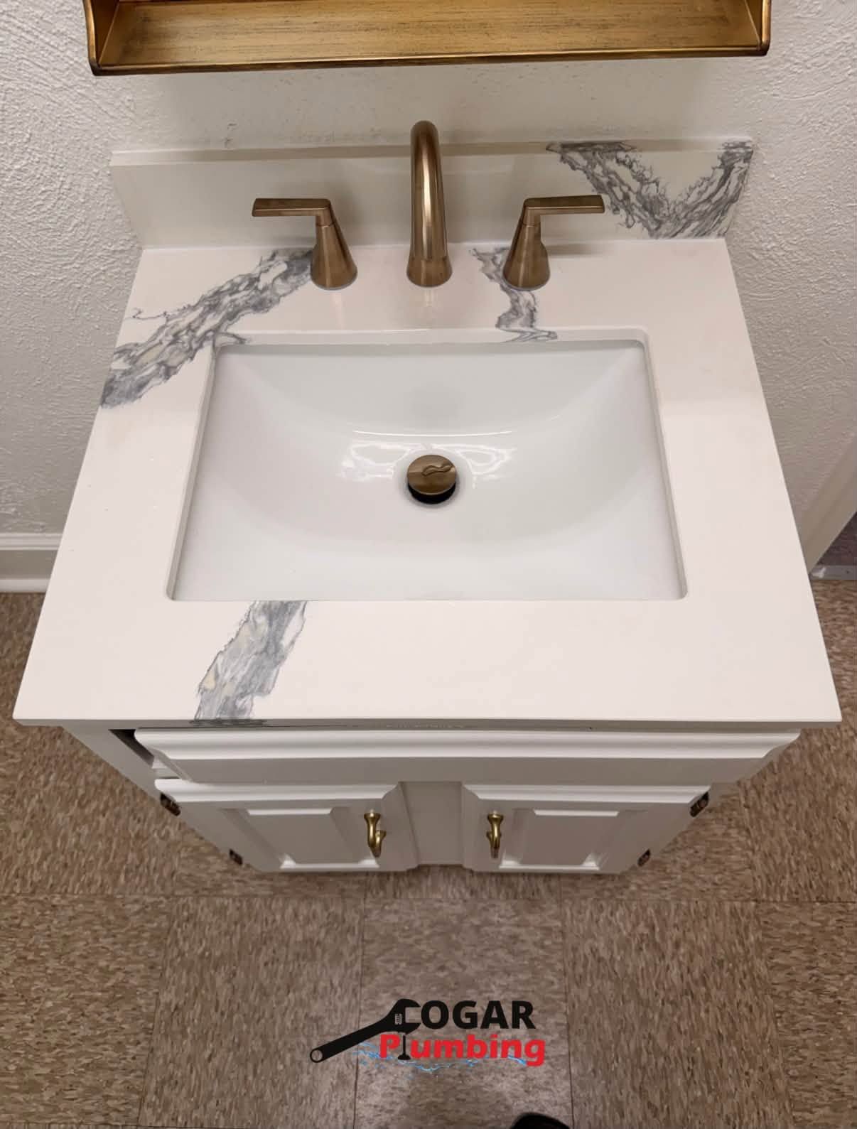 White bathroom vanity with rectangular sink, chrome faucet, and gray marble-style veining on the countertop.