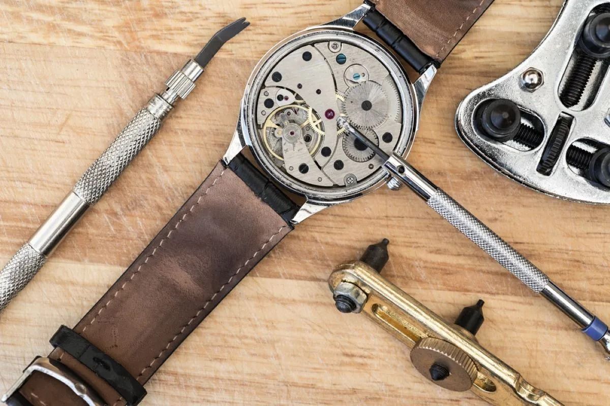Watch Being Repaired With Tools on a Wooden Surface — Coastal Clocks & Watches in Buddina, QLD
