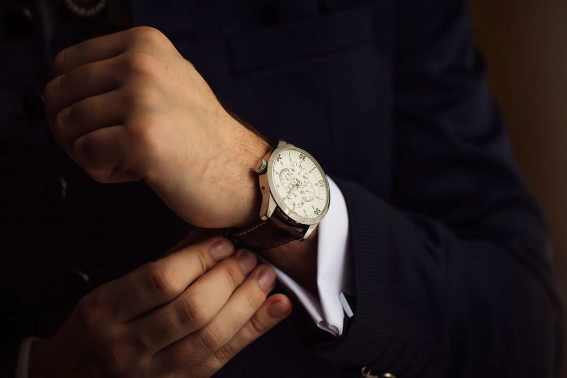 Man Adjusting Wristwatch; Dark Blue Suit, White Cuff — Coastal Clocks & Watches in Buddina, QLD