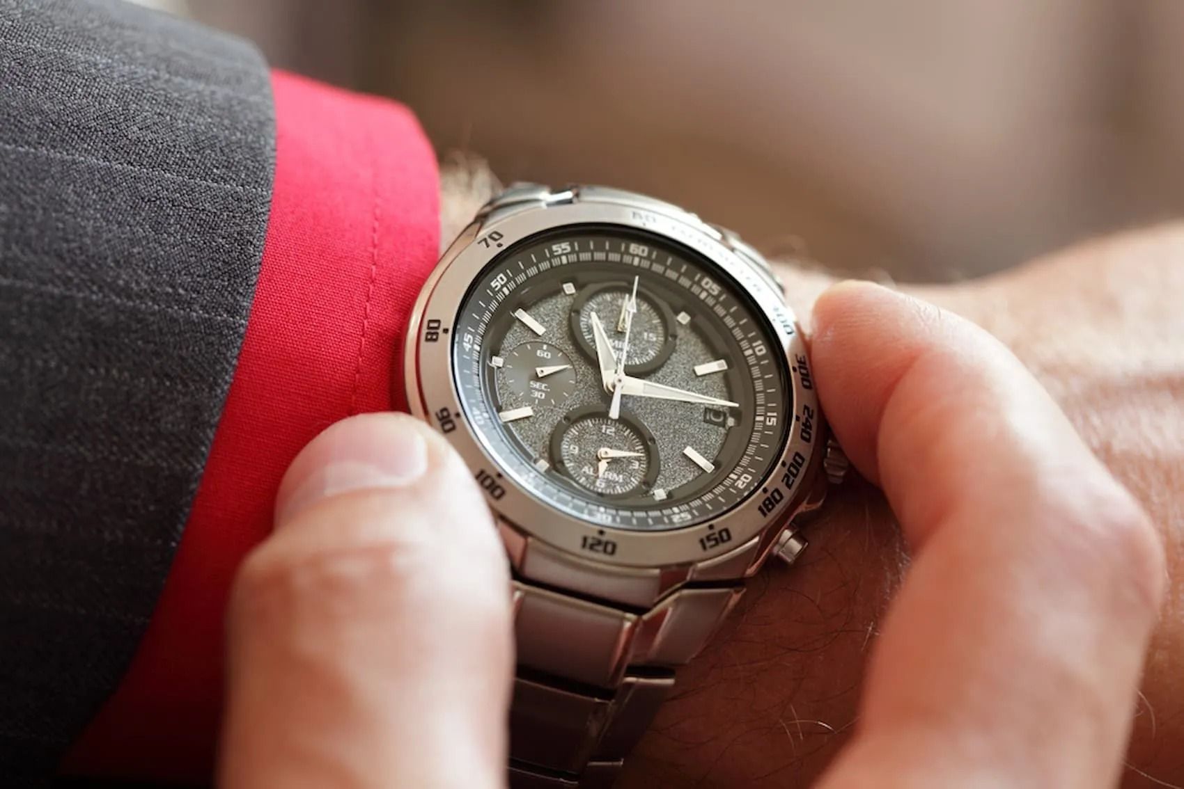 Man's Wrist With a Silver Wristwatch; He's Adjusting the Watch, Close-up — Coastal Clocks & Watches in Buddina, QLD
