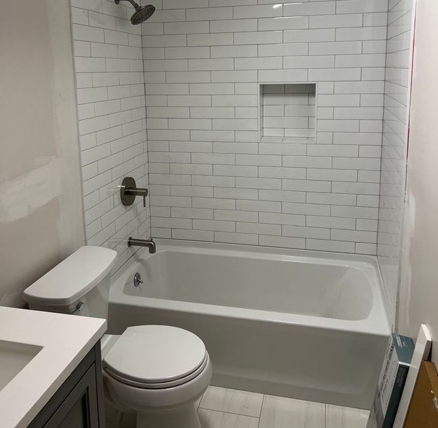A bathroom with a toilet a tub and a shower