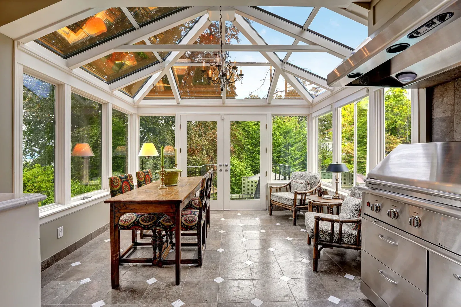 Stone outdoor pavilion with a dark wooden roof, built-in grill, and bench seating.