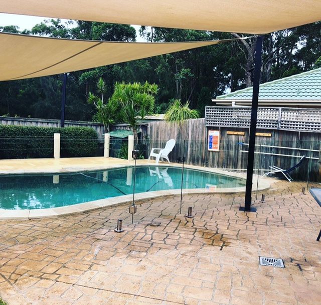 Pool Area With Turquoise Water and Beige Patio — Long Jetty Glass in The Entrance, NSW