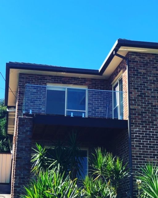 Two-story Brick Building With a Balcony Featuring a Glass Railing — Long Jetty Glass in The Entrance, NSW