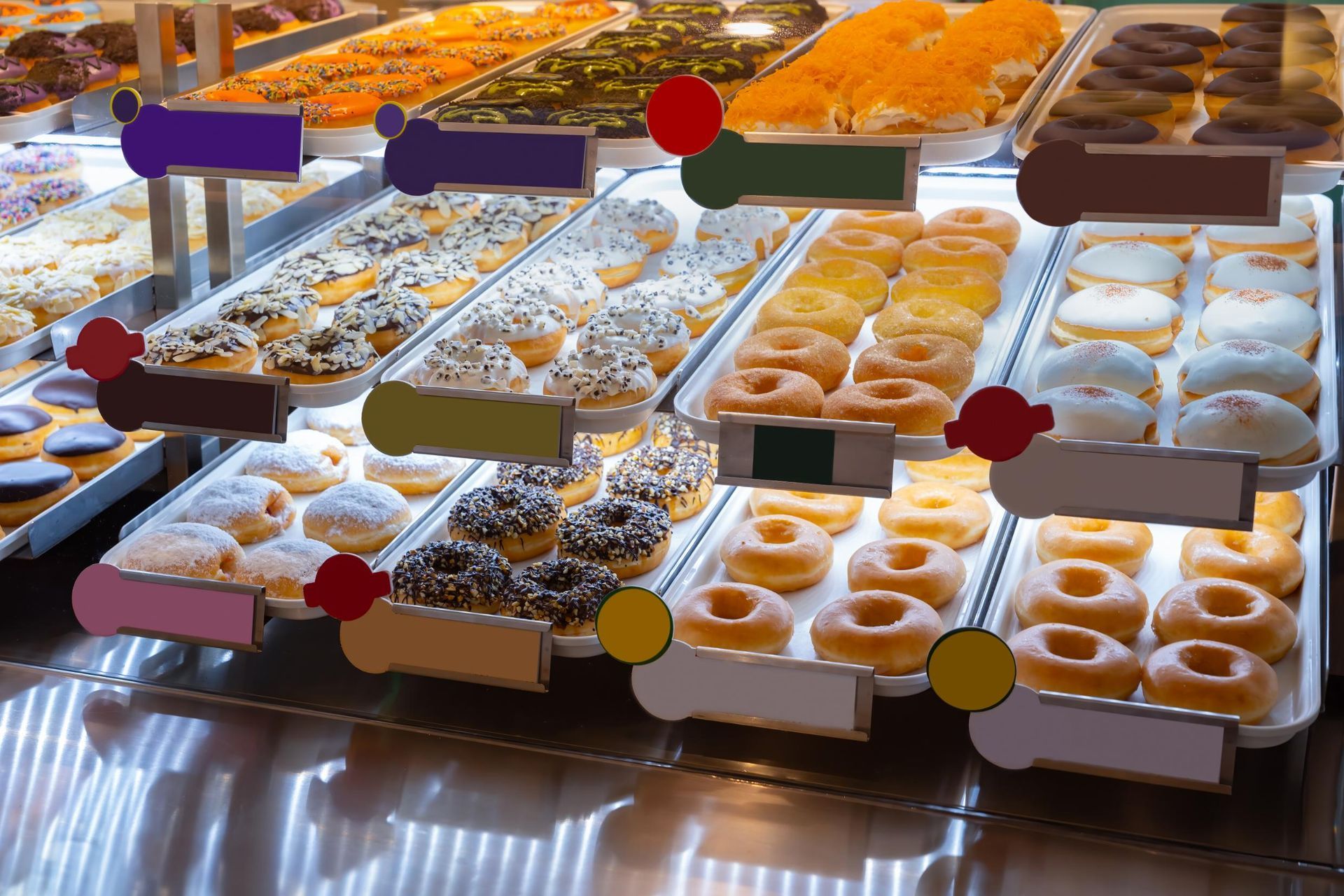 Donut display case filled with various glazed and frosted donuts in a bakery.