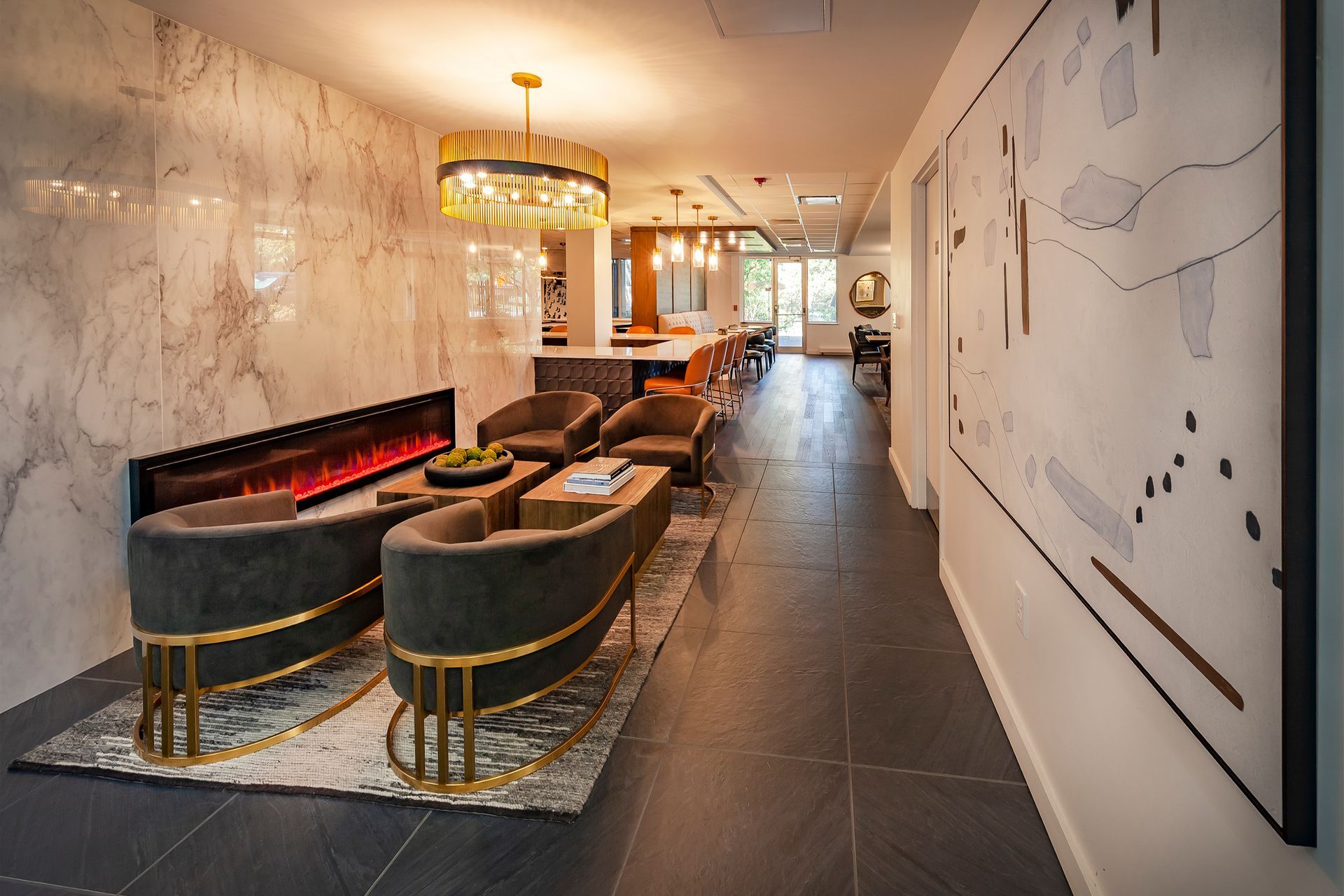 A living room with a fireplace , chairs , and a chandelier at  Riley Towers, Indianapolis, IN. 
