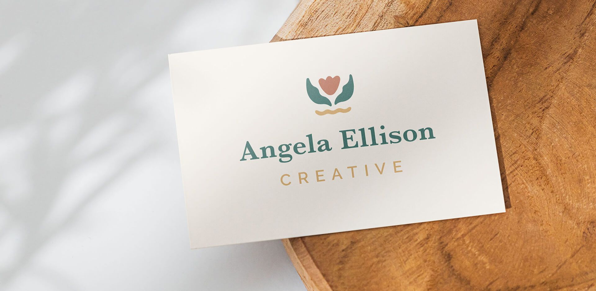 business card, sitting on top of a wood slab with new logo for woman-owned small business