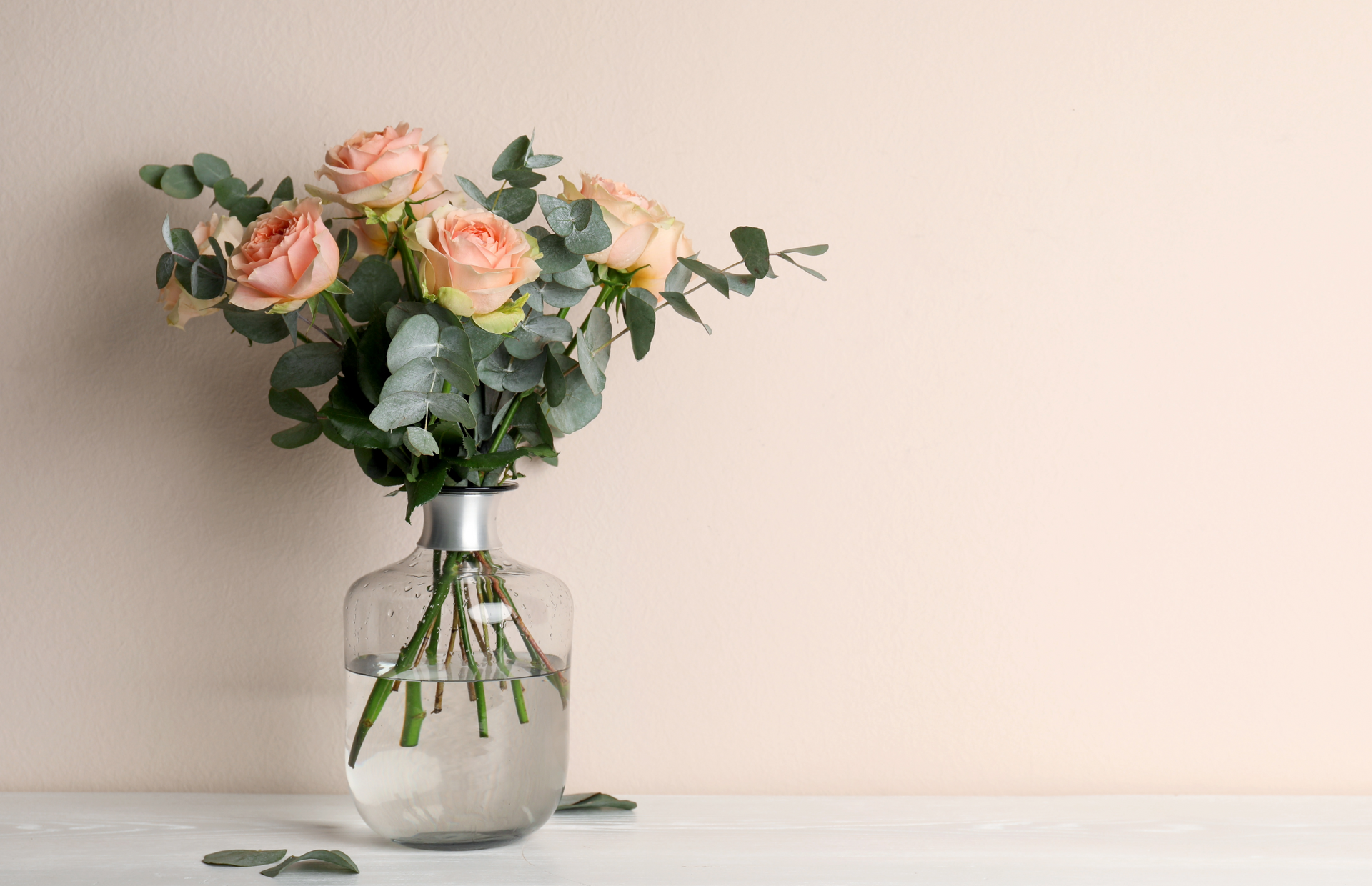 full bouquet of roses with added greenery in a glass vase