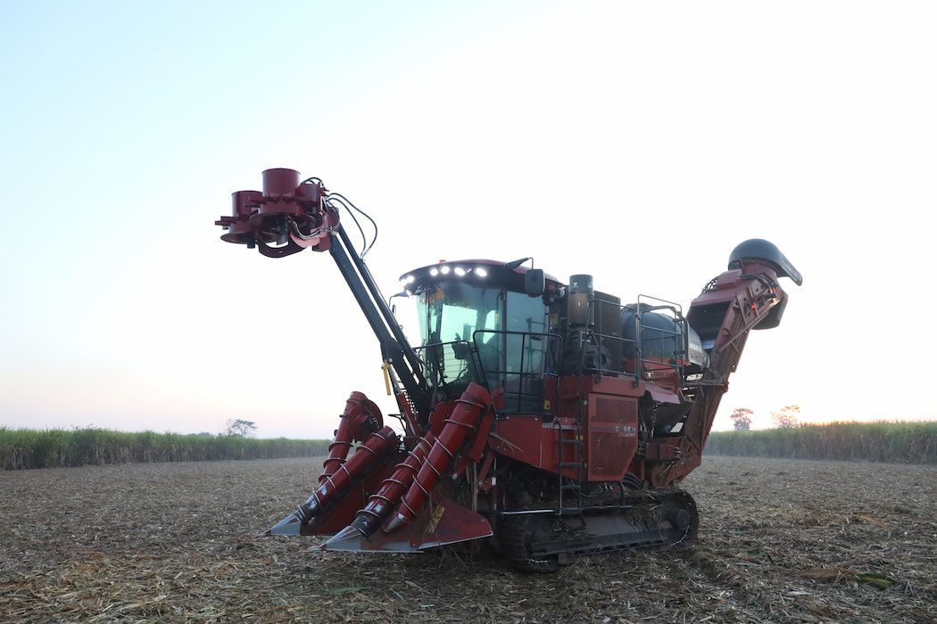 A Red Tractor Is Sitting in The Middle of A Field — Cheshire Machinery in Svensson Heights, QLD