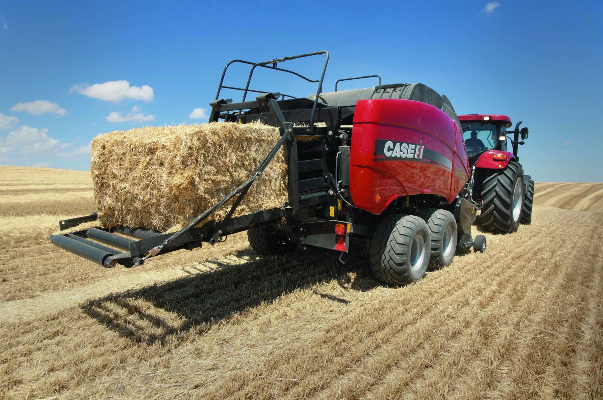 A Red Tractor Is Parked on A Lush Green Field — Cheshire Machinery in Murgon, QLD