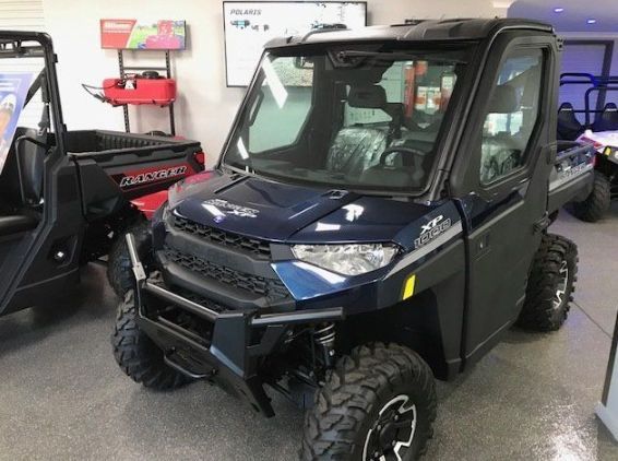 A Blue Atv Is Parked in A Showroom Next to A Red Atv — Cheshire Machinery in Svensson Heights, QLD