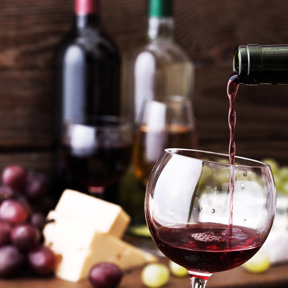 A glass of wine is being poured from a bottle