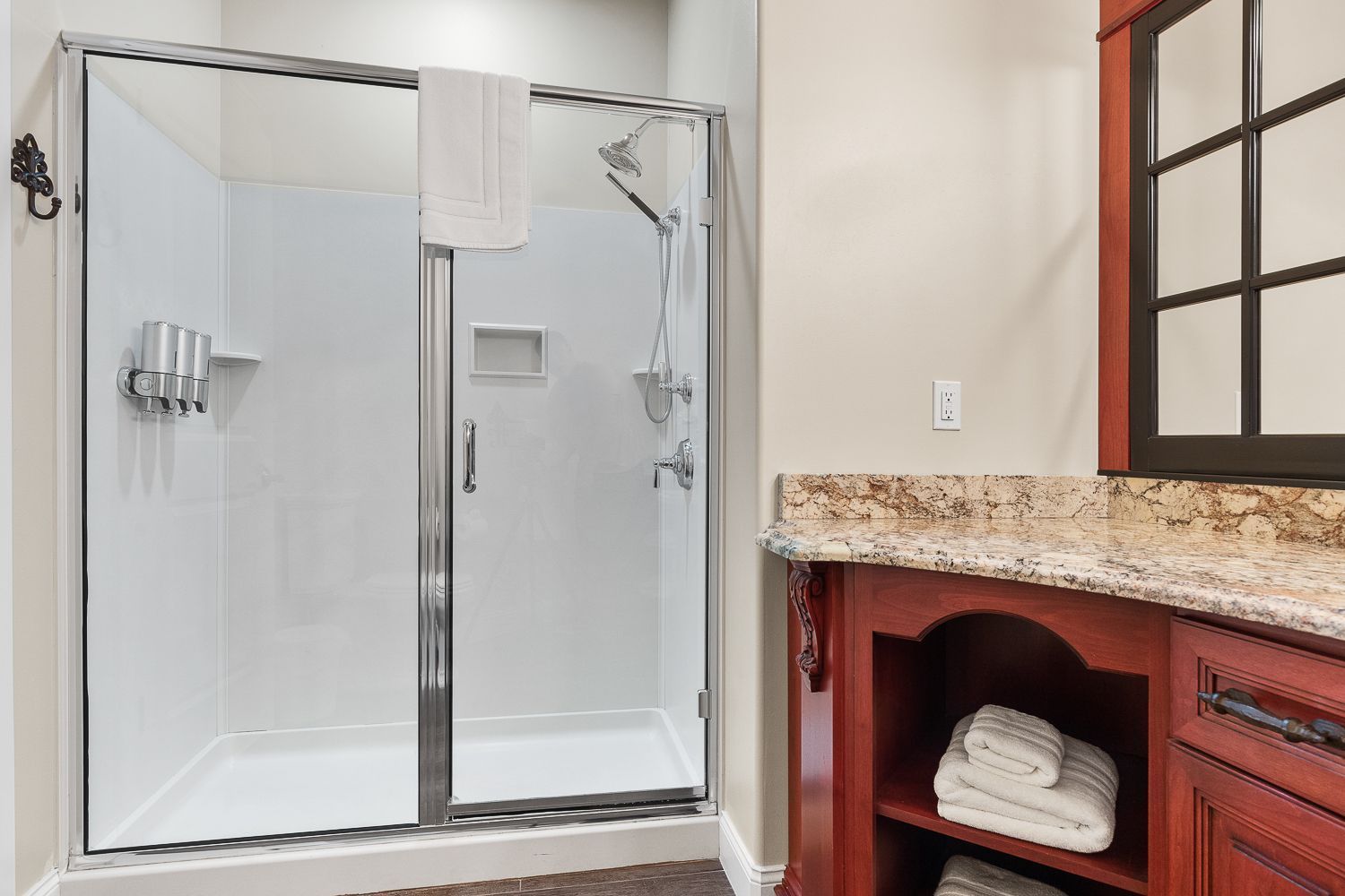A bathroom with a walk in shower and a sink.