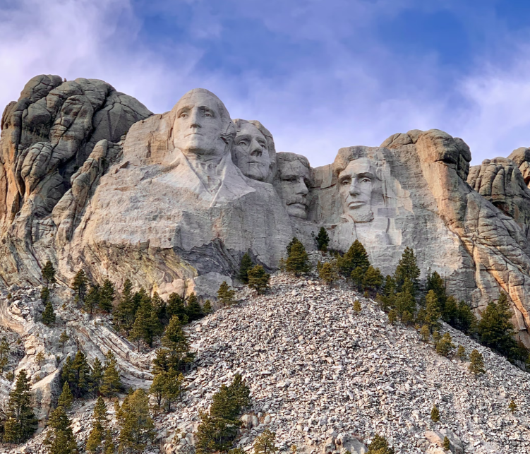 A large rock formation with four faces carved into it