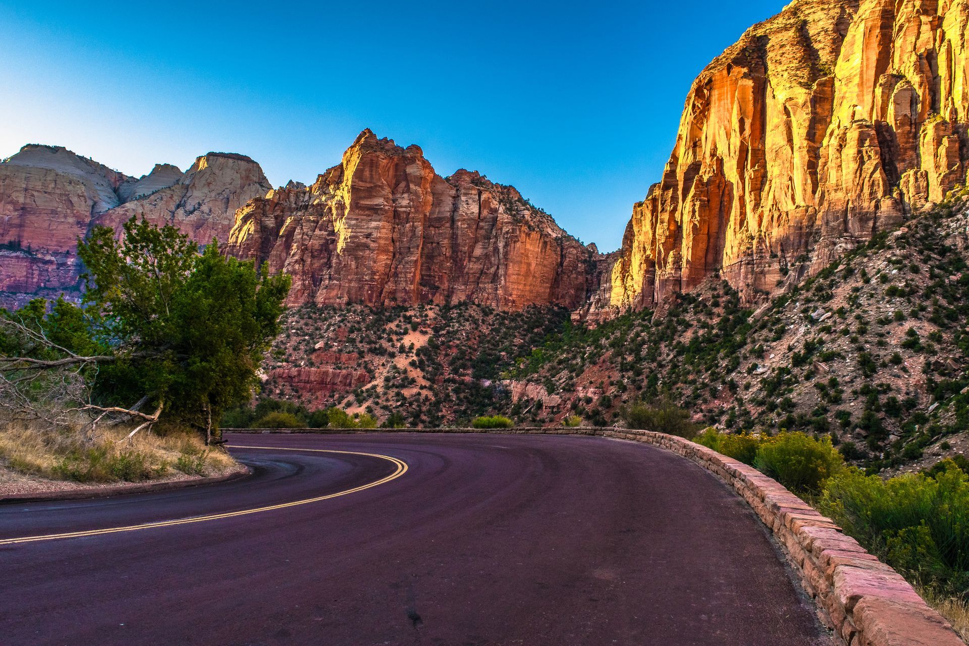 A road going through a canyon with mountains in the background.