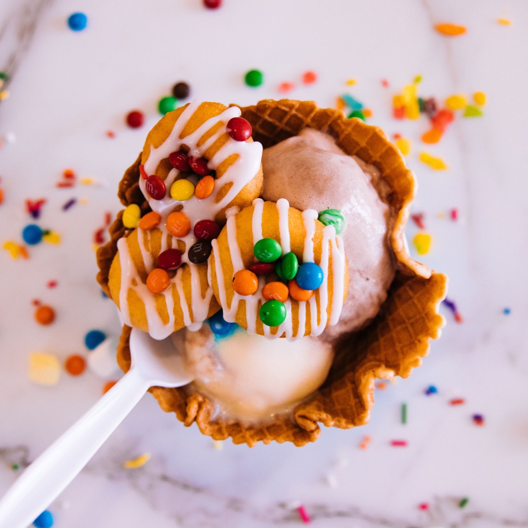 A waffle cone with ice cream and sprinkles.