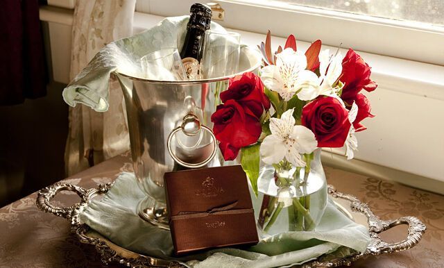 A tray with a bottle of champagne and flowers on it