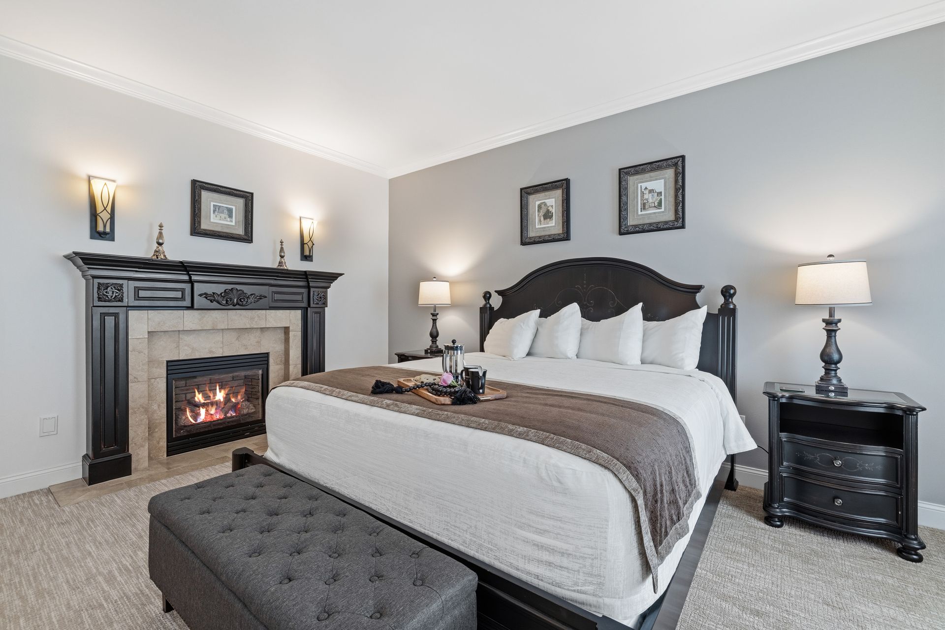 A bedroom with a king size bed and a fireplace.