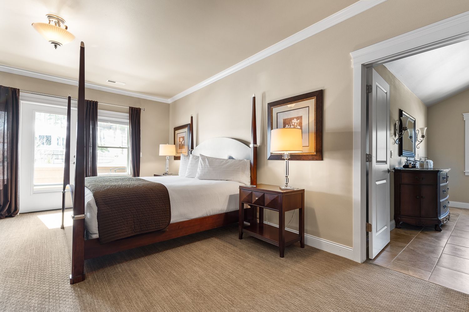 A bedroom with a four poster bed and two lamps