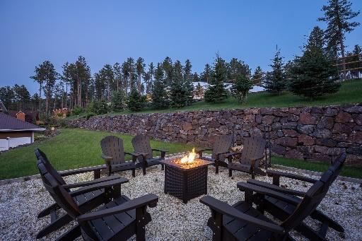 A group of chairs are sitting around a fire pit.