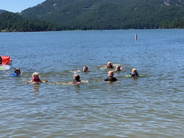 A group of people are swimming in a lake.