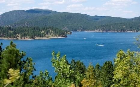 A large body of water surrounded by trees and mountains