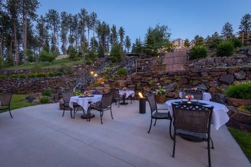 A patio with tables and chairs and a fire pit.