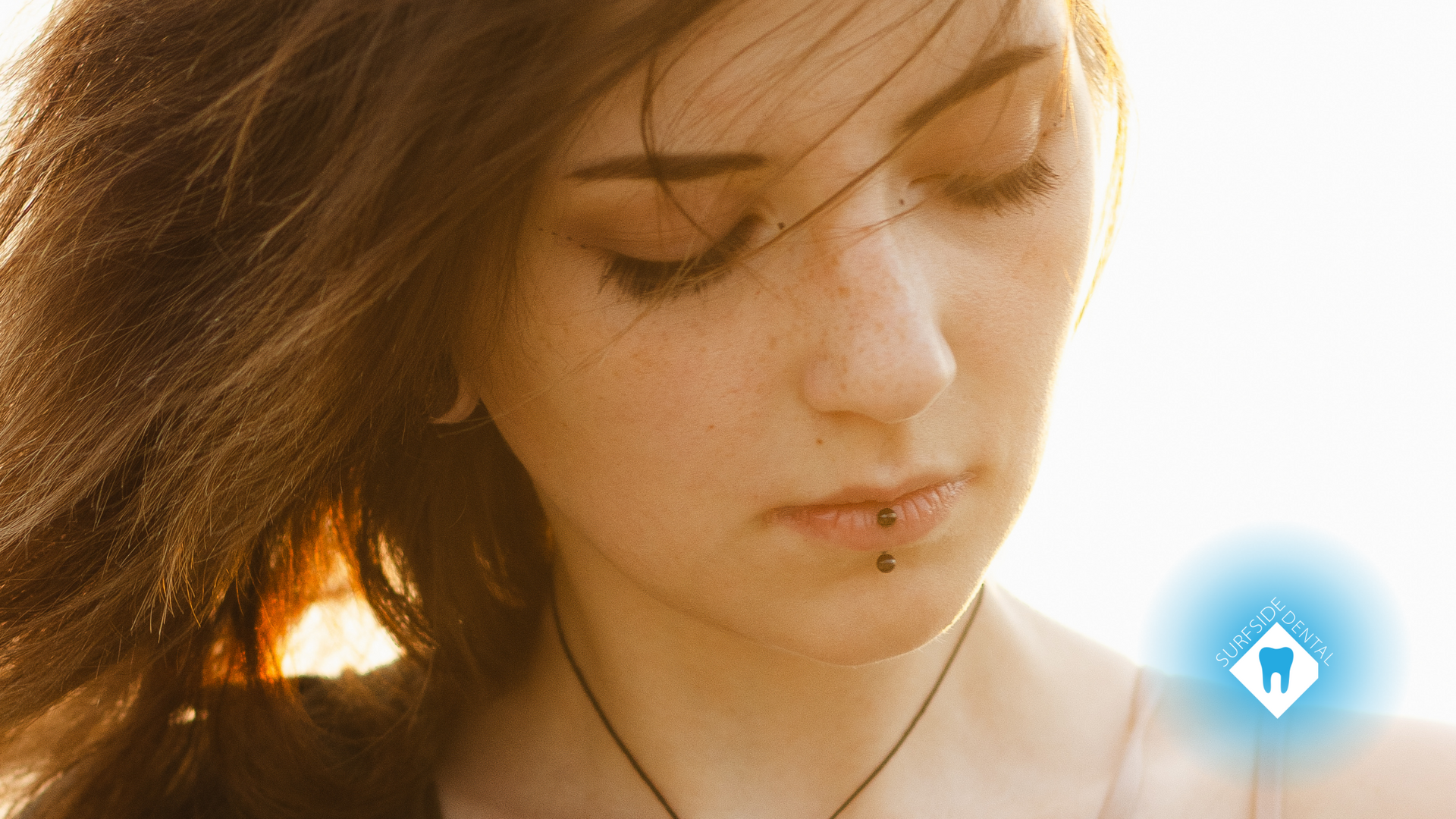 A close up of a woman 's face with a necklace around her neck.