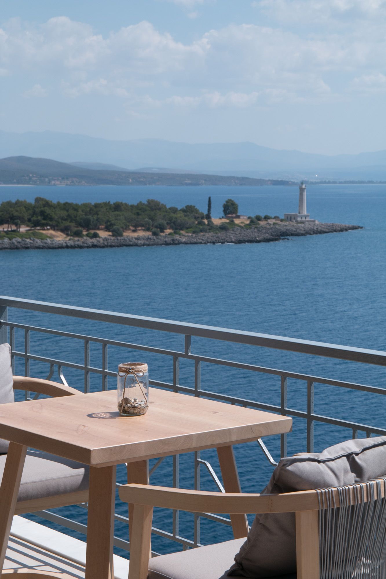 A table and chairs on a balcony overlooking the ocean
