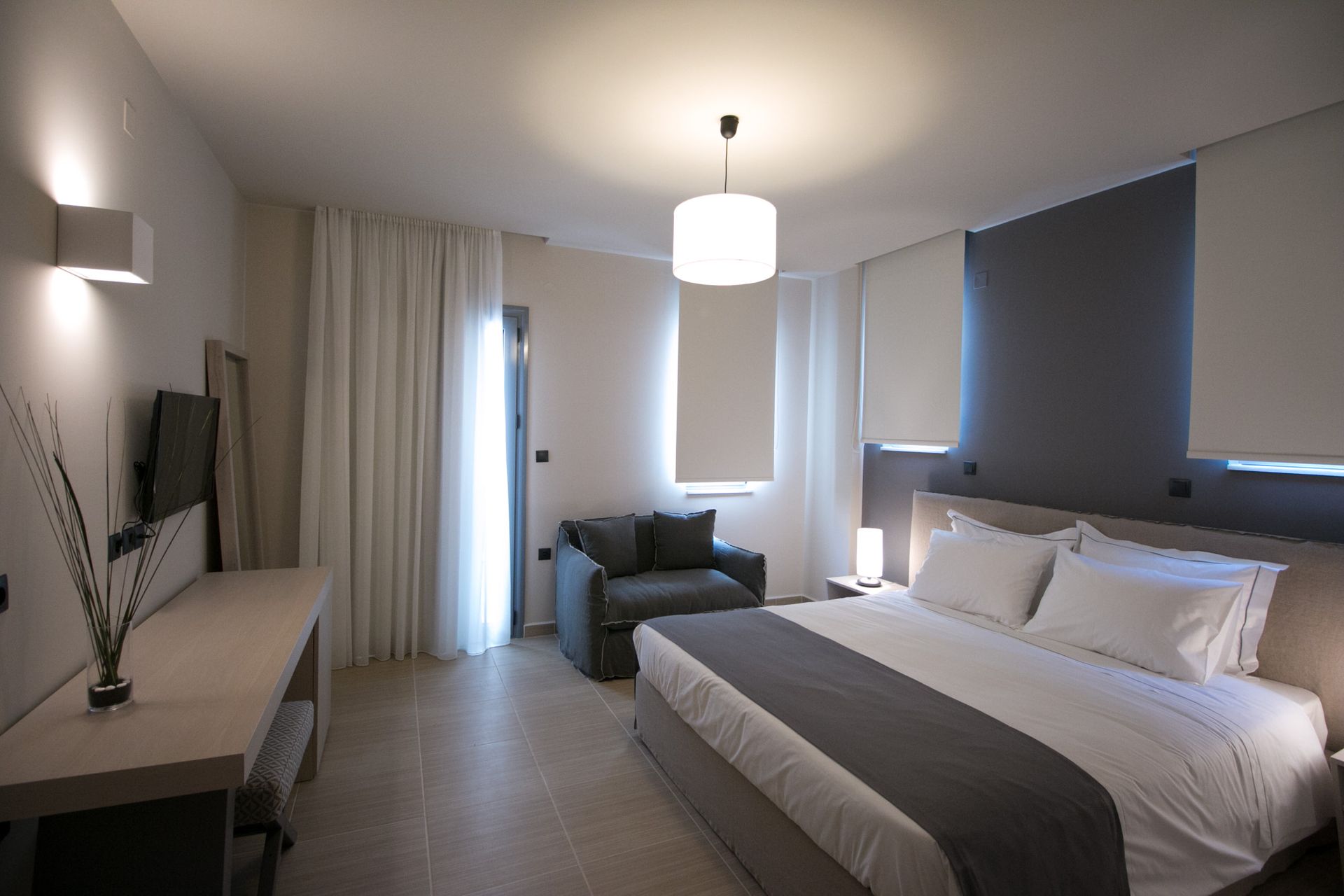 A hotel room with a large bed and a chair