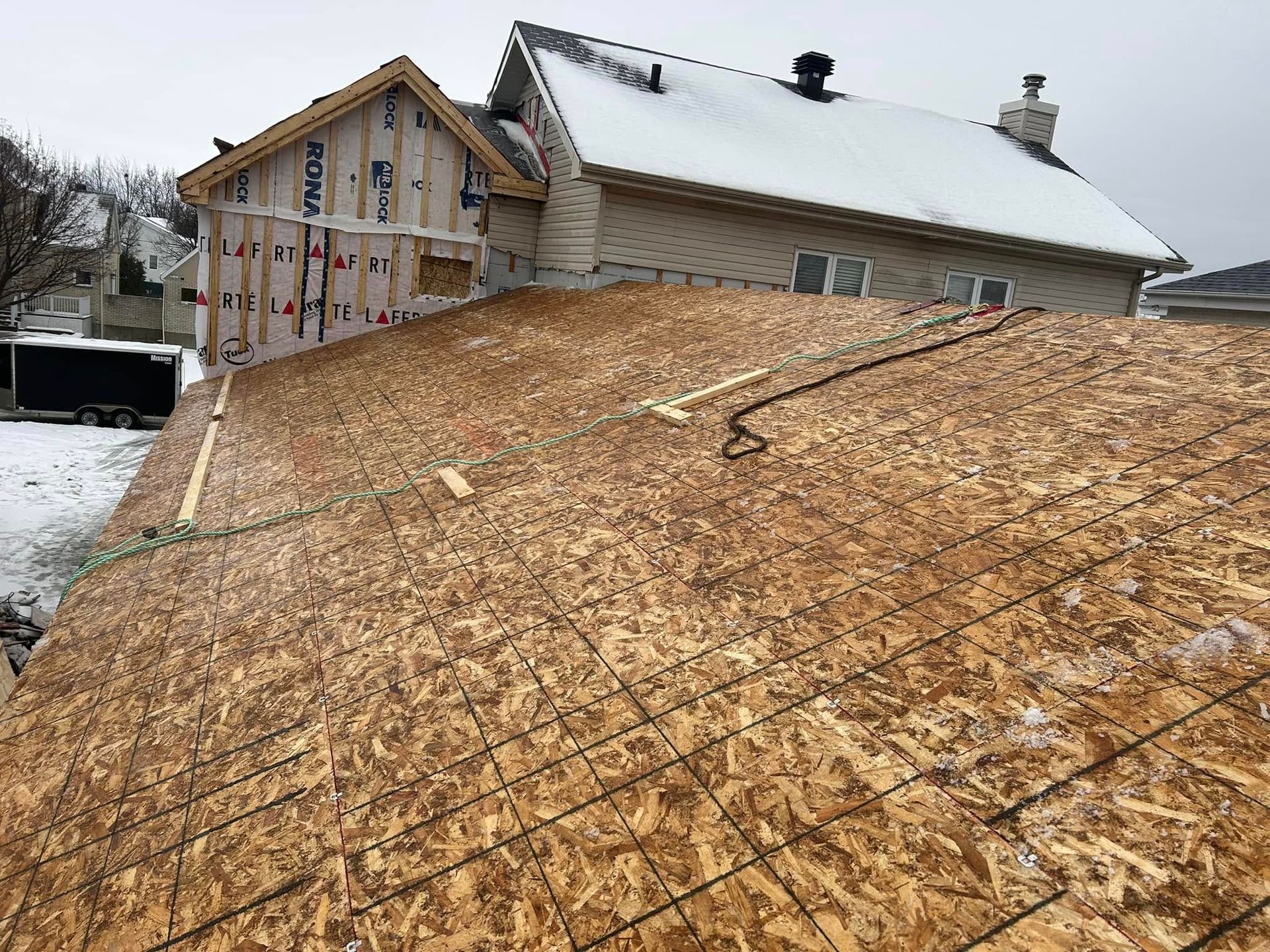 Une maison est en construction sur une colline avec beaucoup de contreplaqué sur le toit.