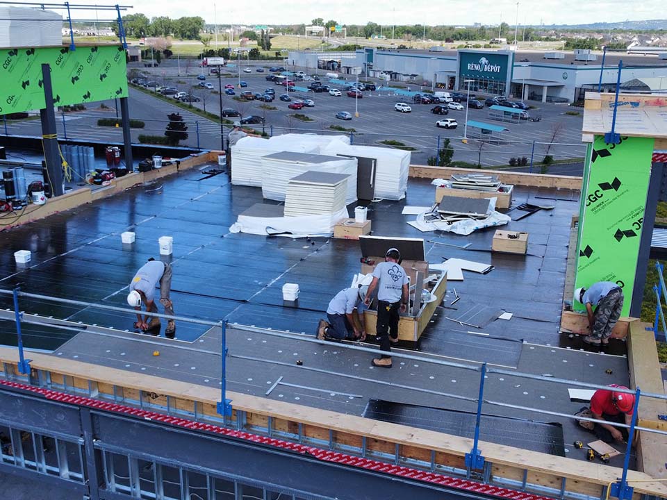Un groupe d'ouvriers du bâtiment travaille sur le toit d'un bâtiment.
