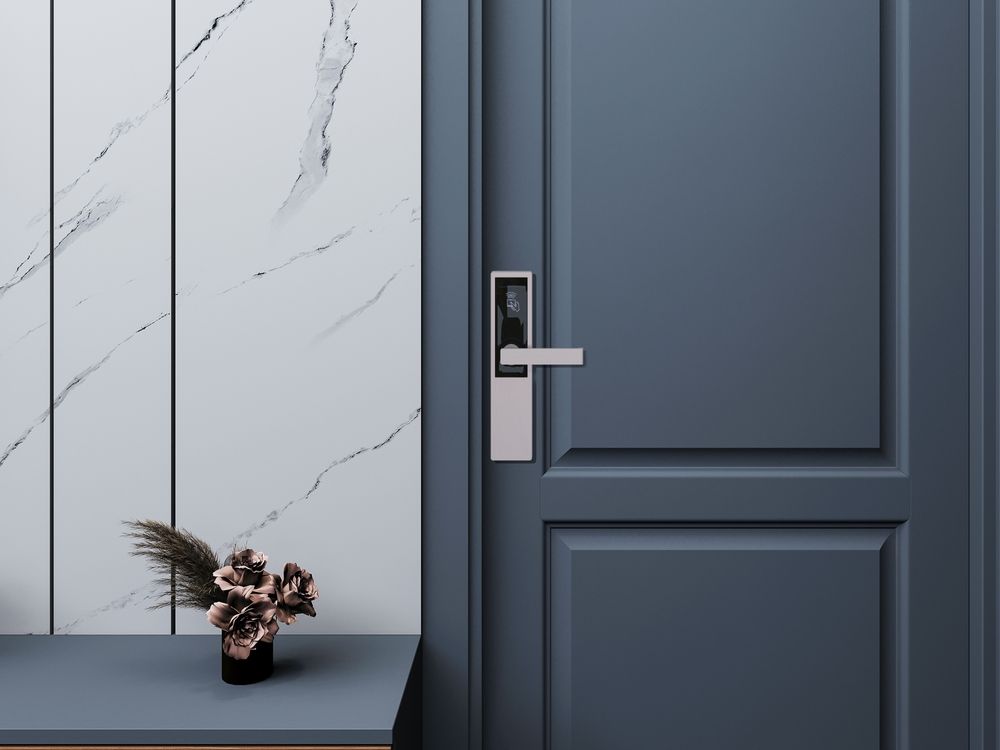 Una porta blu con una maniglia e un vaso di fiori su un tavolo.