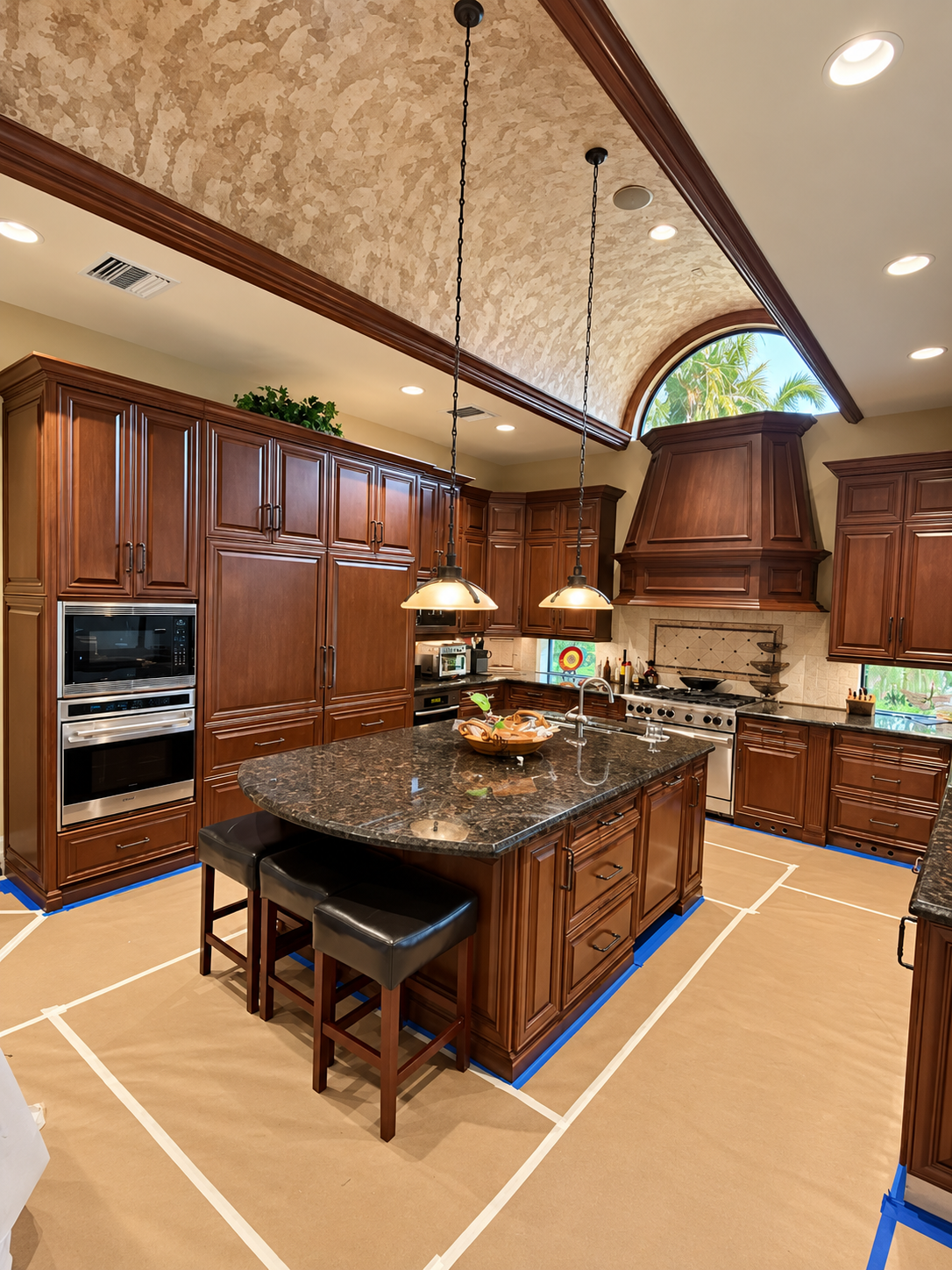 Spacious luxury kitchen with dark wood cabinets, black granite island, and vaulted ceiling with pendant lights
