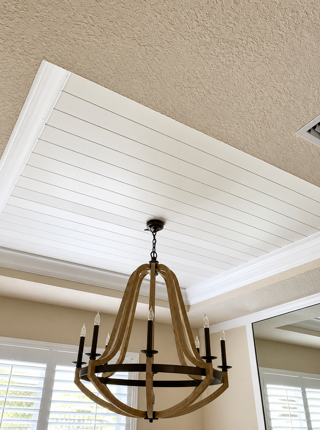 Chandelier with rope detail hanging from a white coffered ceiling in a bright room