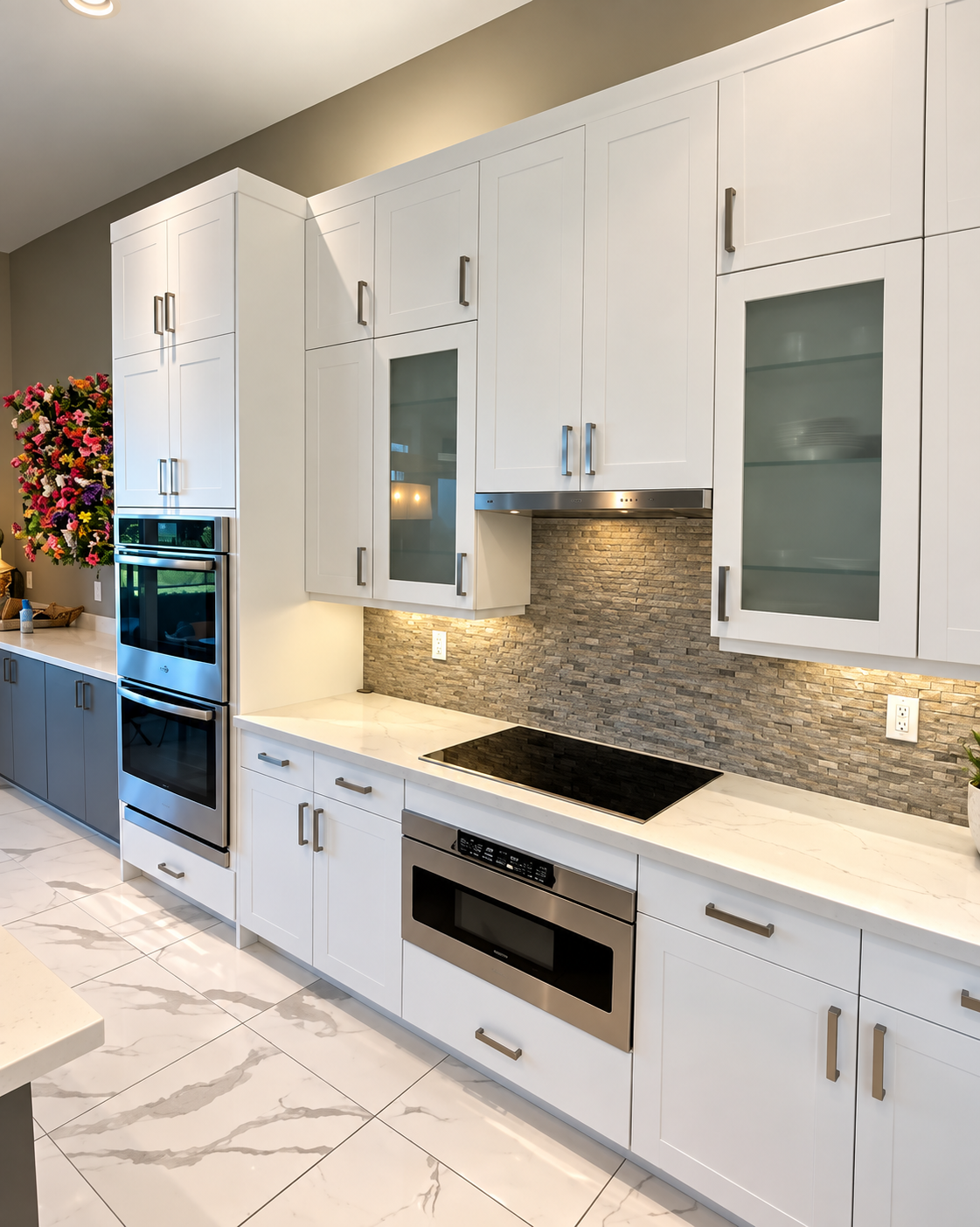 Bright modern white kitchen with marble floors, built-in oven, cooktop, and glass-front cabinets