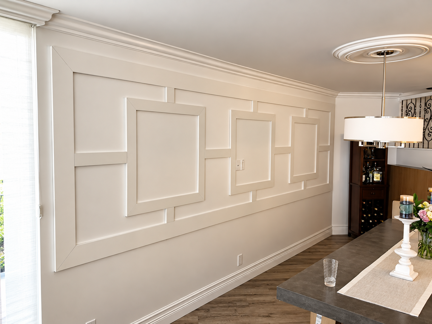 Elegant dining room with cream paneled wall, chandelier, and a table set with white decor