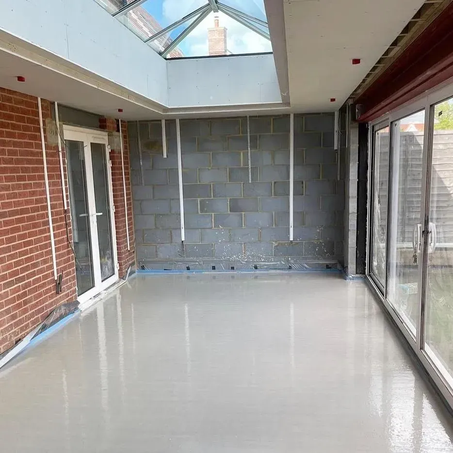 The same extension with a layer of liquid screed installed, covering the underfloor heating system.