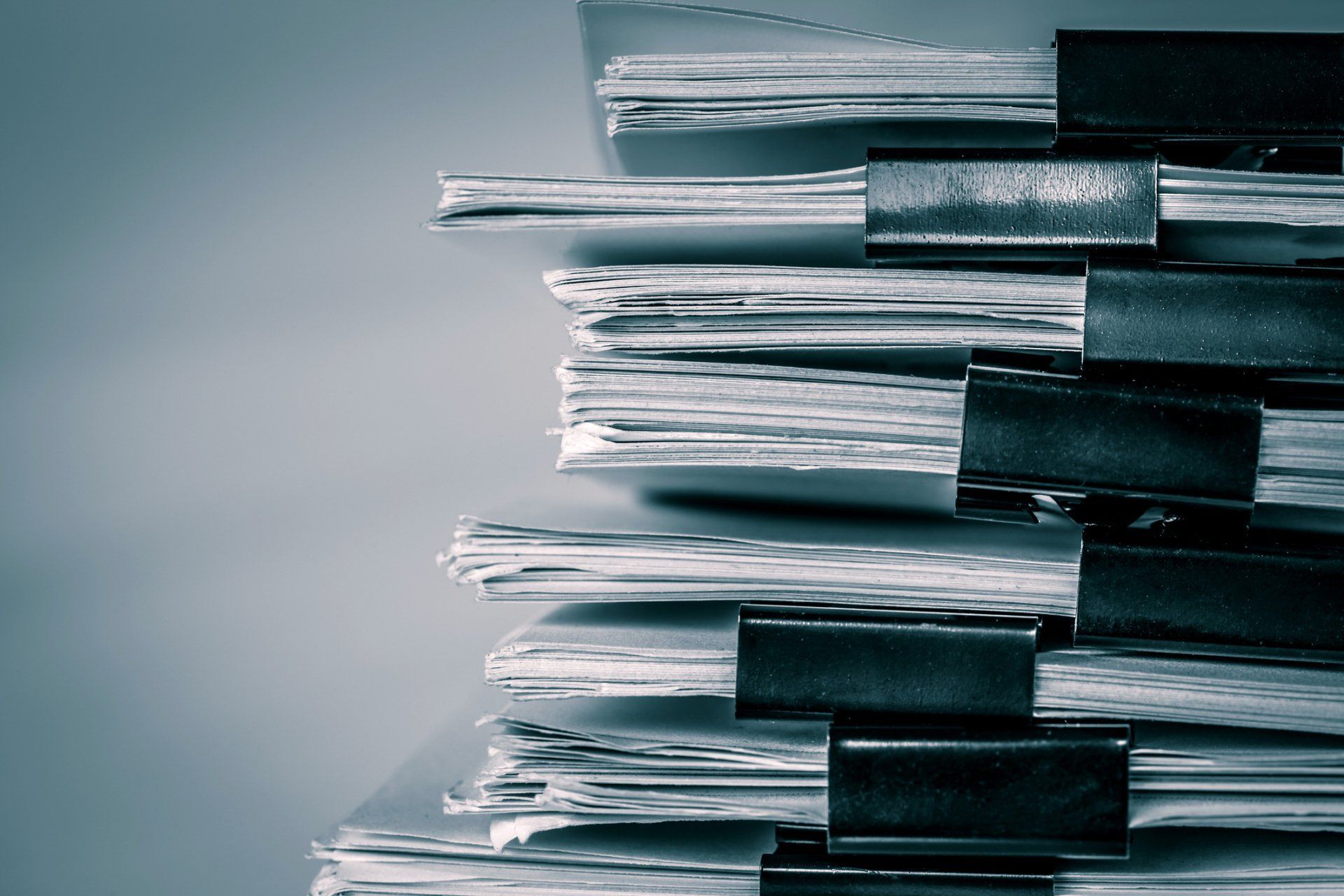 A stack of papers with black clips on them.