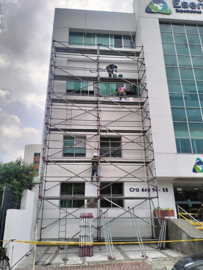Andamios cubren la fachada blanca de un edificio.