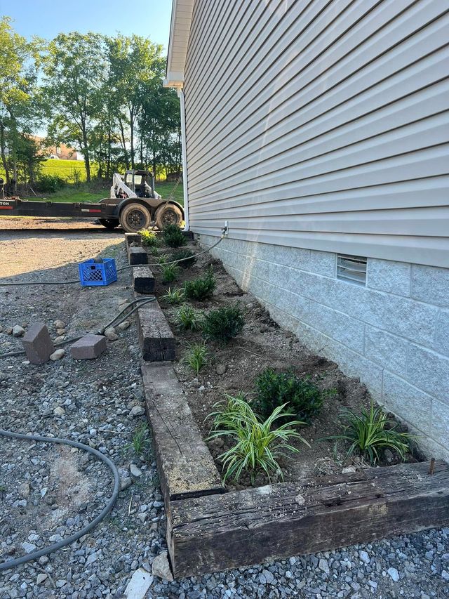A house with a garden in front of it and a bulldozer in the background.