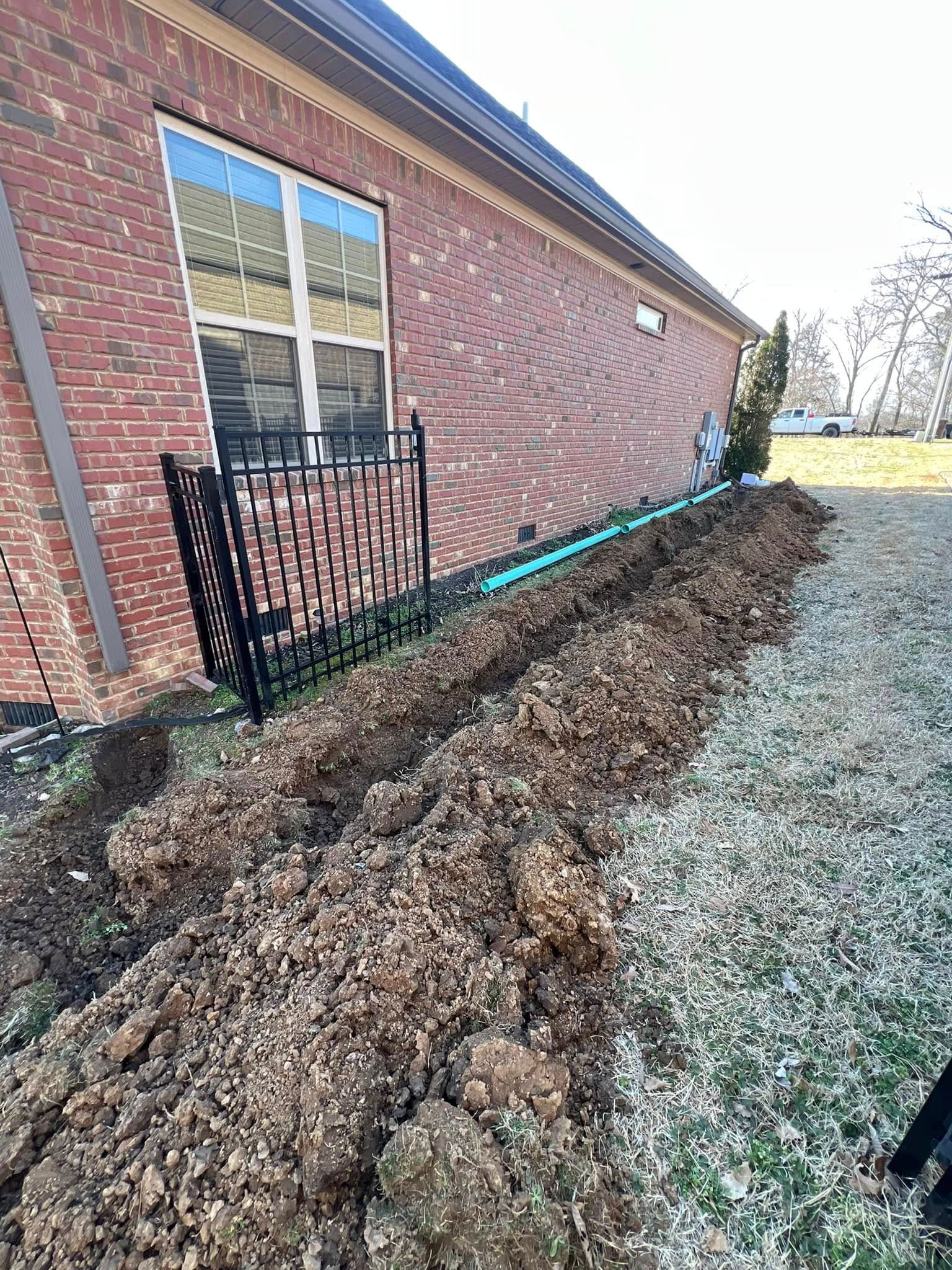 A large pile of dirt is sitting in front of a brick building.
