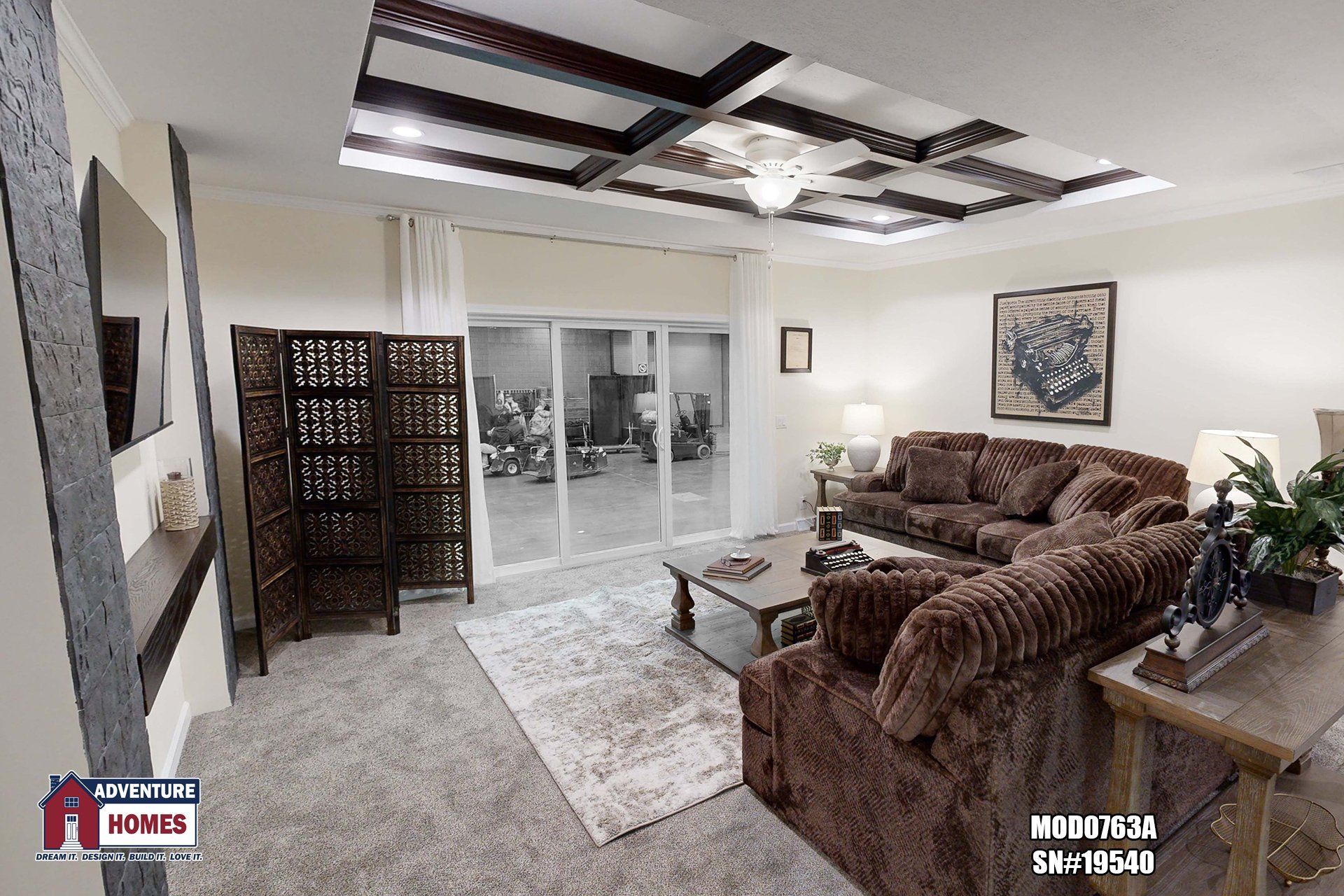 Cozy living room with brown sectional, wood screen, and sliding glass doors.