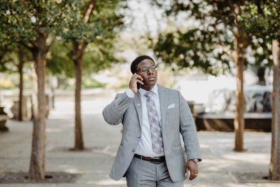 A man walking in the park talking on the phone