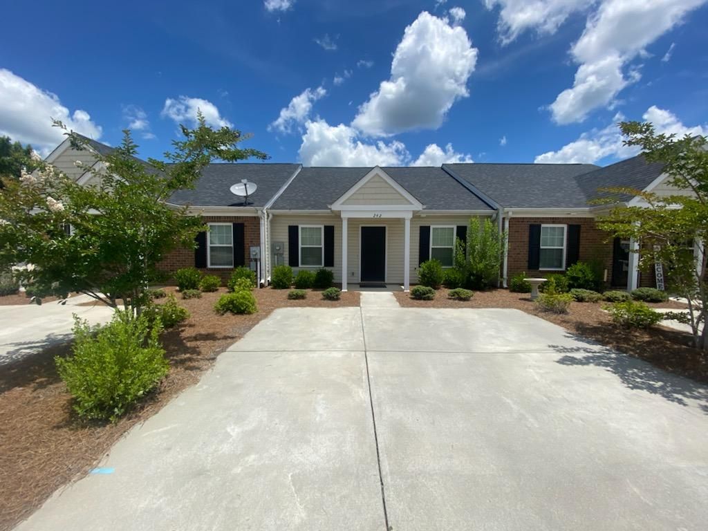 A large brick house with a satellite dish on the roof