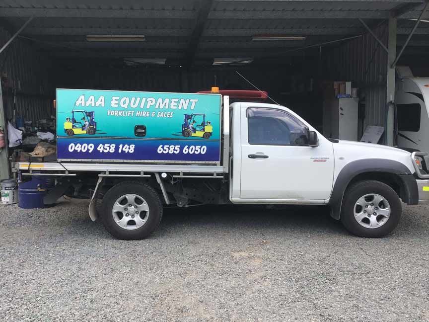 A White Truck Is Parked in A Gravel Lot in Front of A Building — AAA Equipment Pty Ltd In Forster, NSW