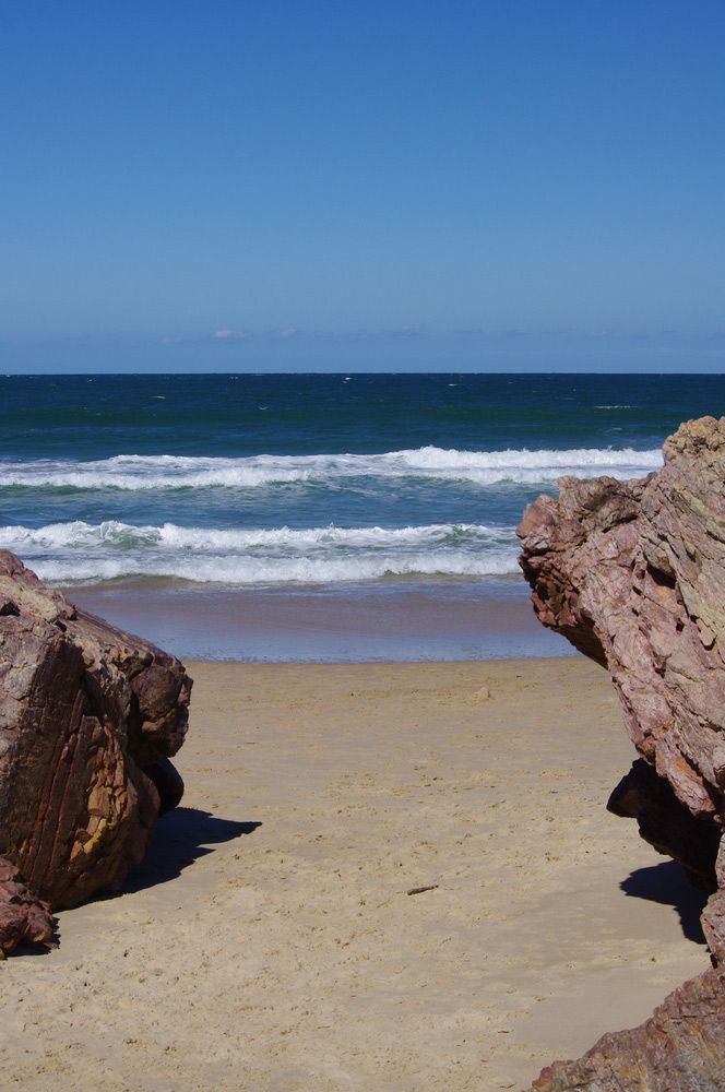 A Beach with Rocks in The Foreground and The Ocean in The Background — AAA Equipment Pty Ltd In Port Macquarie, NSW