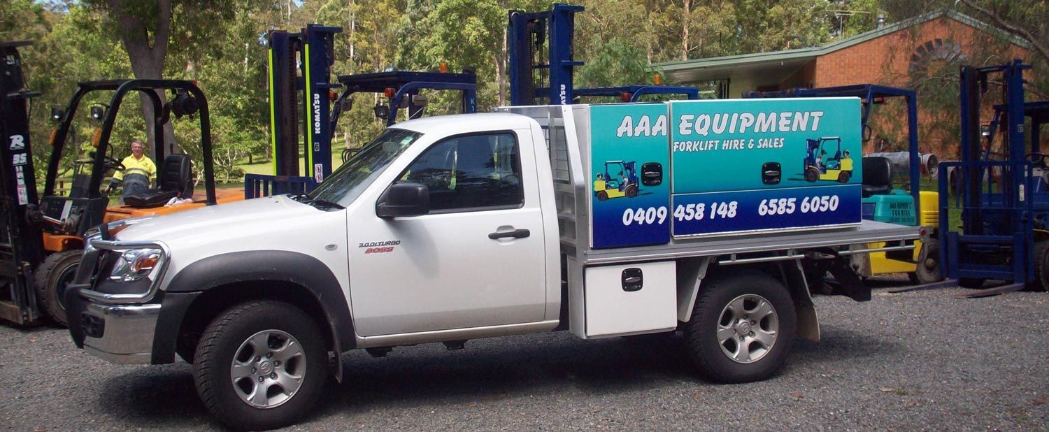 A White Truck Is Parked in Front of A Forklift — AAA Equipment Pty Ltd In Taree, NSW