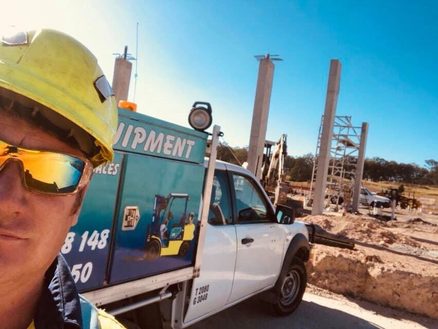 A Man Wearing a Hard Hat and Sunglasses Is Standing Next to A Truck that Says Equipment — AAA Equipment Pty Ltd In Taree, NSW